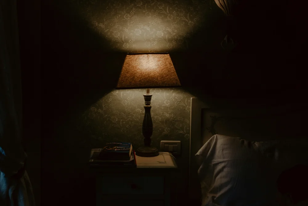 dark room with a bedside lamp lighting the room