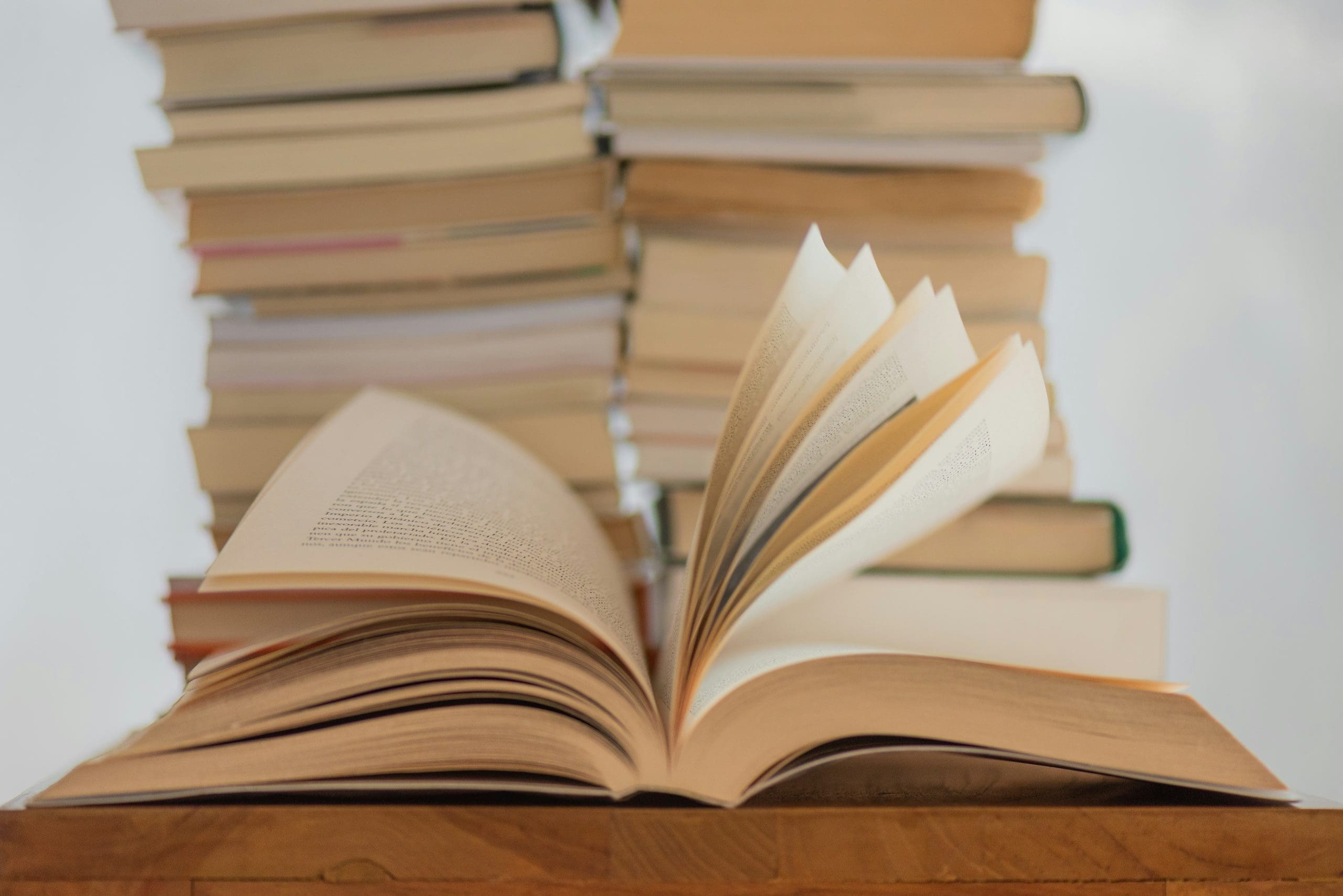 open book sitting in front of stack of closed books
